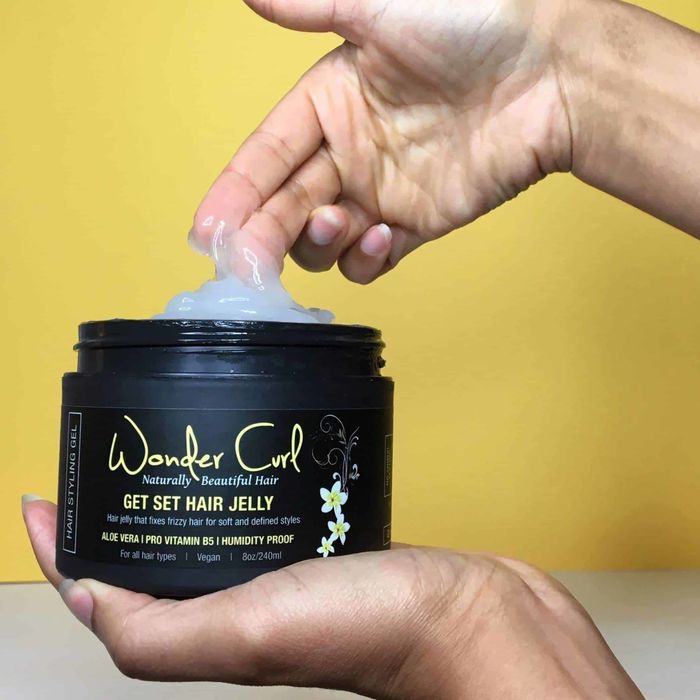 A hand scooping up the jelly from the container