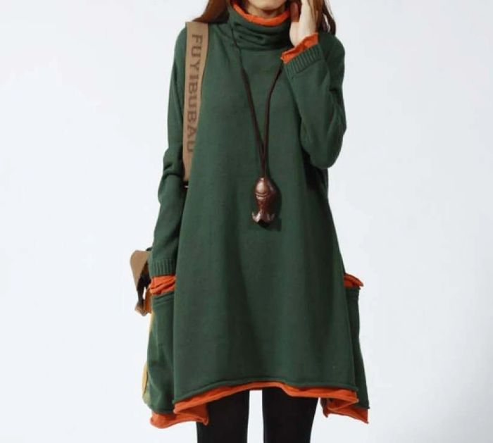 The model is wearing a green and orange dress combined with black tights.