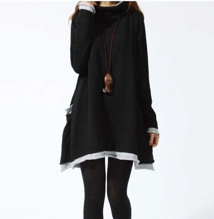The model is wearing a black and gray dress paired with black tights.