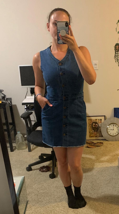 A reviewer wearing a blue mini dress