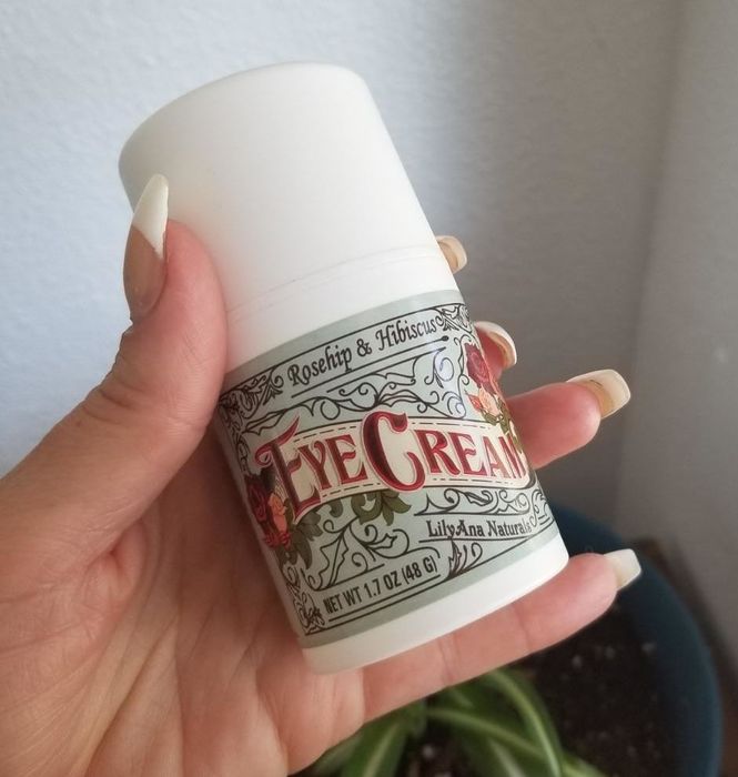 A reviewer holding up a 1.7-ounce bottle