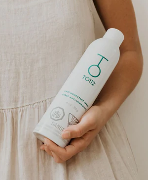 model showcasing the can of TO112 Anti-Humectant Spray