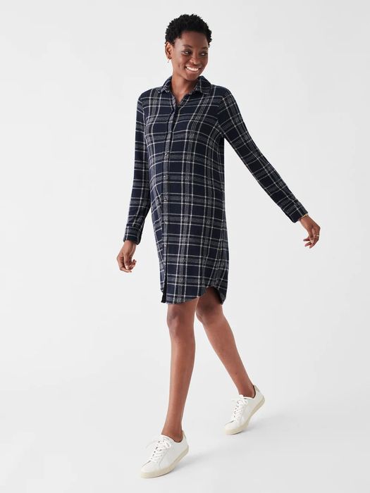 The model is showcasing a blue and white plaid tunic, complemented with white sneakers.