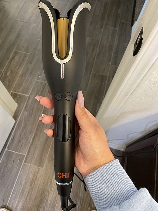 A reviewer holding their Chi Spin N Curl styling tool.