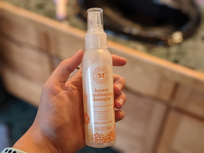 Reviewer holding the citrus-vanilla scented spray