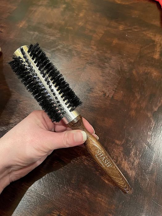 A review shows someone holding the round brush.