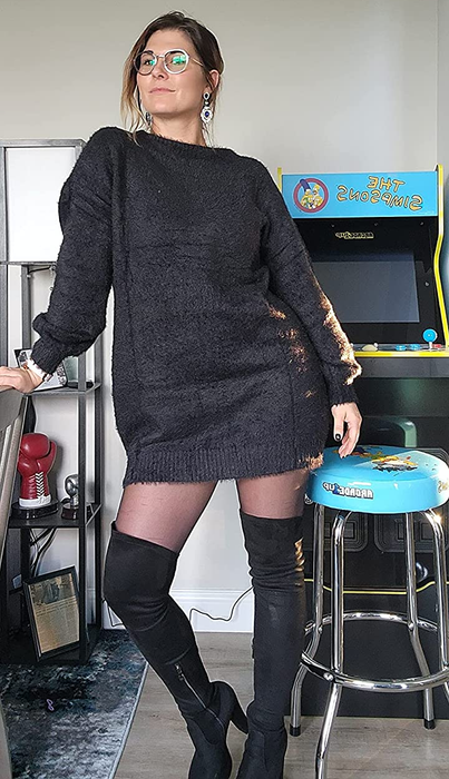 The reviewer is wearing the black dress with black boots.