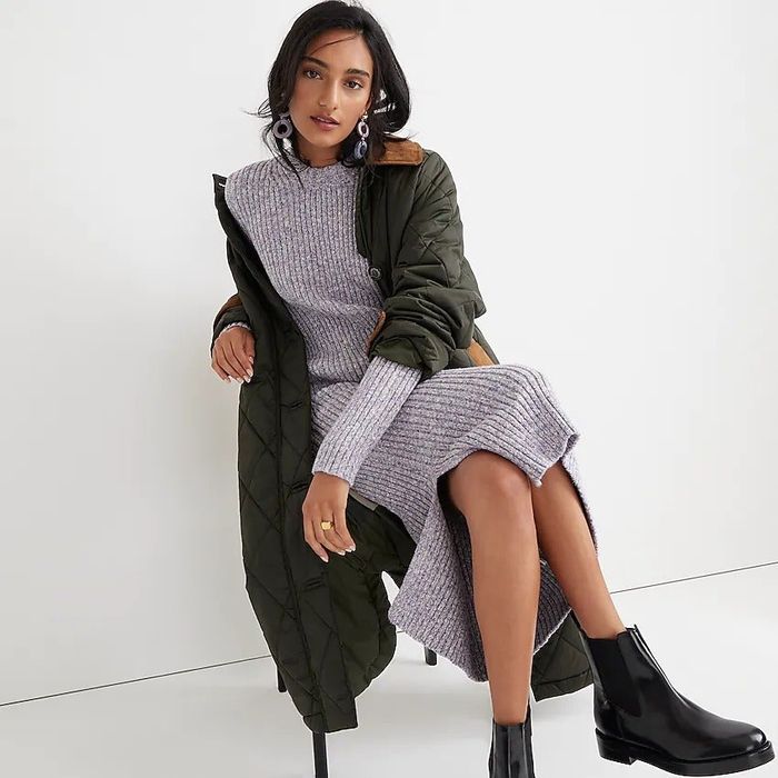 The model is rocking the gray dress with black boots, topped off with a black jacket.