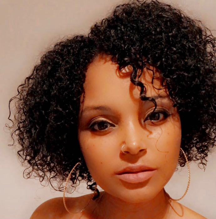 A reviewer showcasing their tight curls after using the product