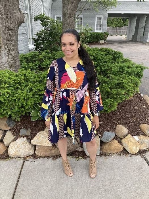 A reviewer wearing the dress in a blue and orange patchwork design