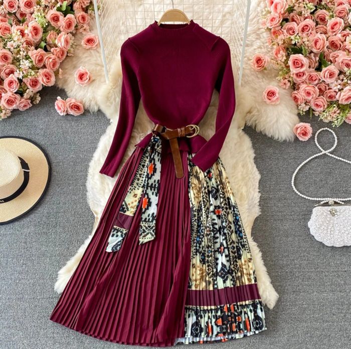 The burgundy dress is styled with a brown waist belt, adding a sleek touch.