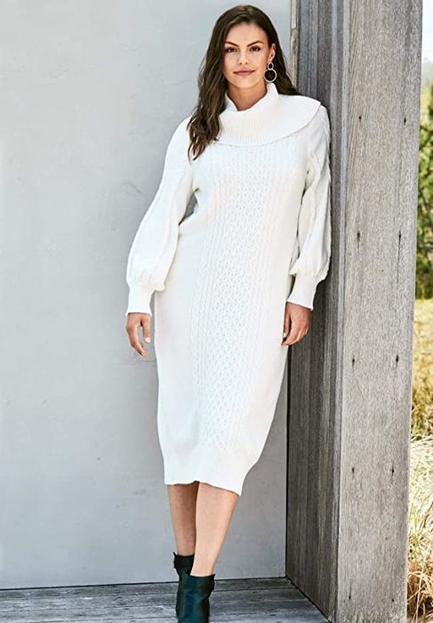 The model is styled in a white dress paired with black boots.