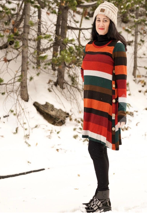 reviewer styled in the multicolored striped dress with black tights and boots