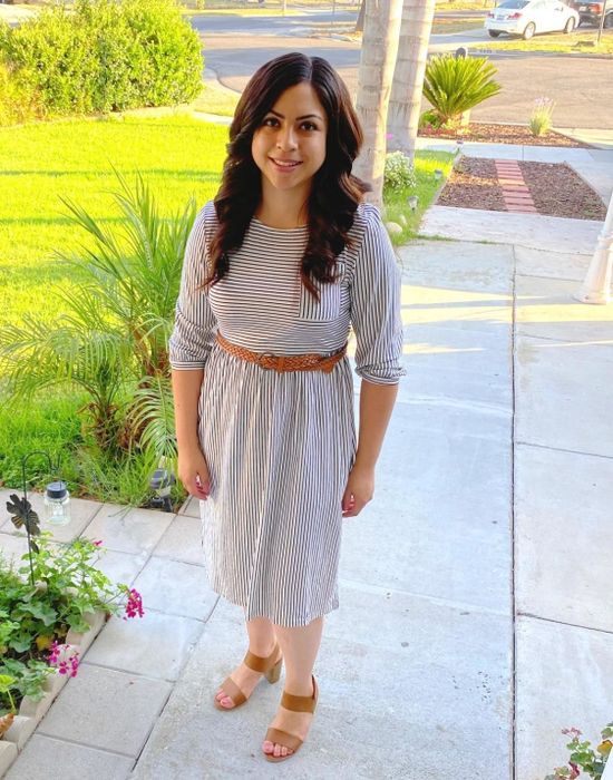 A reviewer wearing the dress in gray stripes