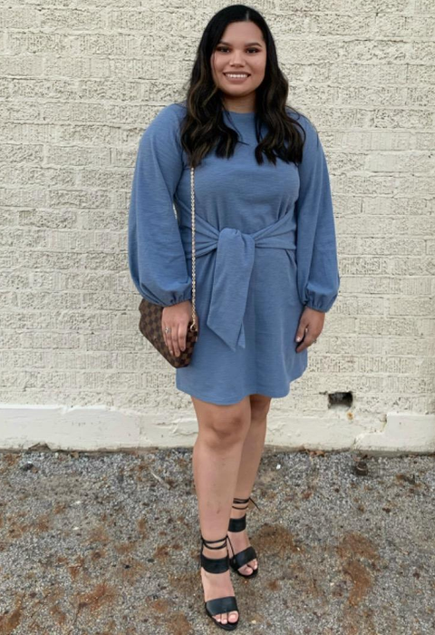 The reviewer is wearing a blue dress paired with black sandals.