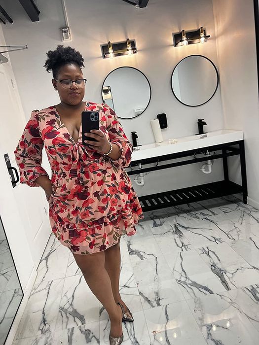 A reviewer showing off the dress in a floral design
