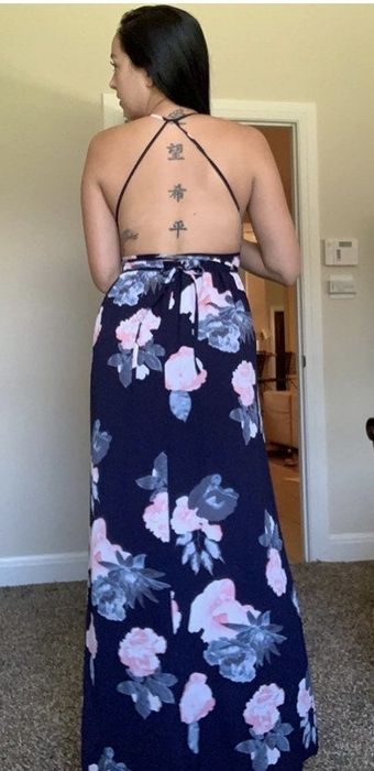 A reviewer wearing a vibrant floral maxi dress