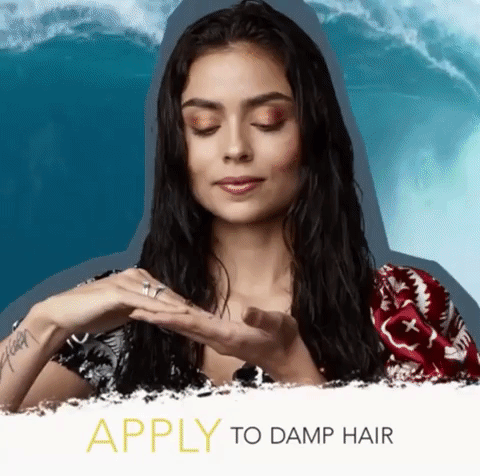 A model twisting and braiding their hair before bed to create waves in the morning