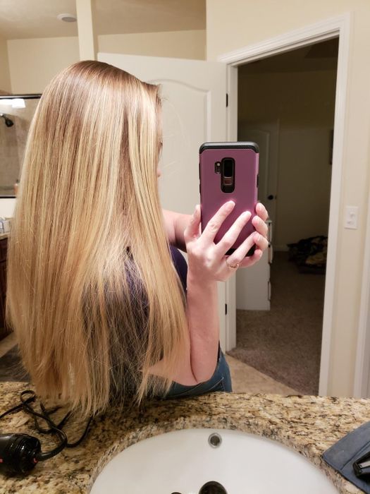 A person with smooth, straight hair after using the styler