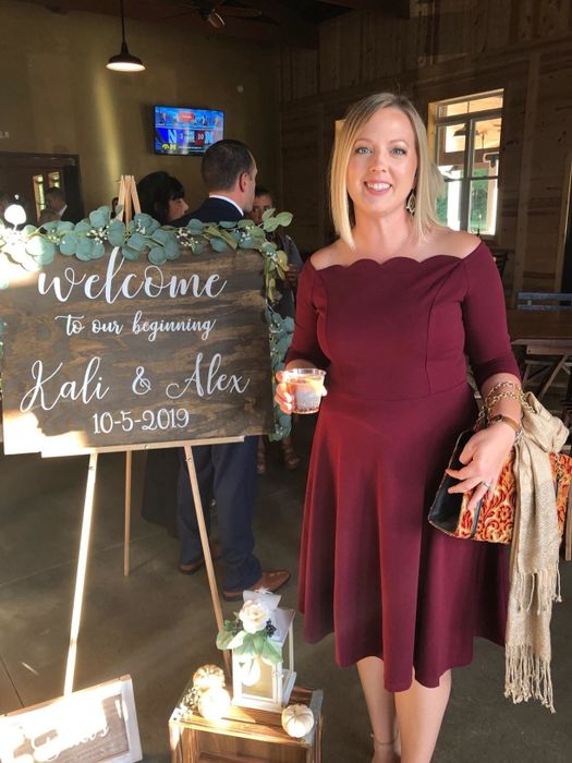 A reviewer wearing the dress in maroon