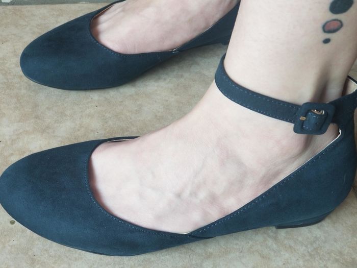A reviewer showing off the shoes in a deep navy color