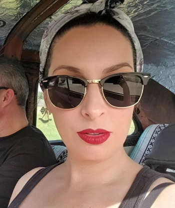 A reviewer wearing bold red matte lipstick.