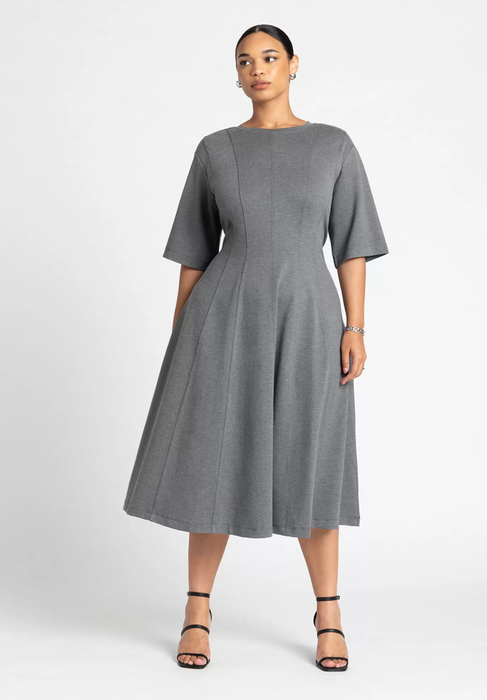 Person in a knee-length A-line dress with elbow-length sleeves and black strappy heels, ideal for a shopping feature