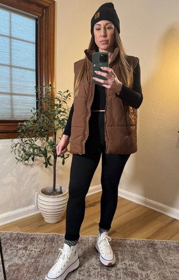 Reviewer wearing a brown quilted vest.