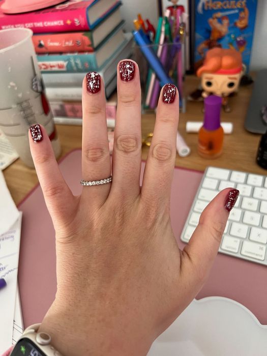 Mytour editor's hand with red nails and silver glitter polish on top