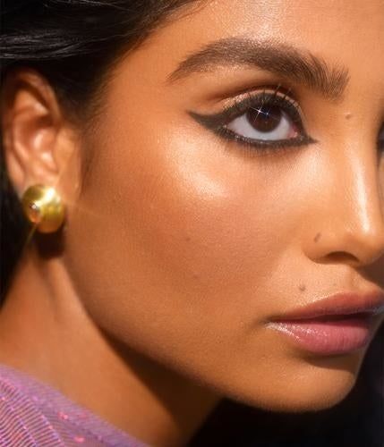 A close-up of a model sporting bold black eyeliner around her eyes.
