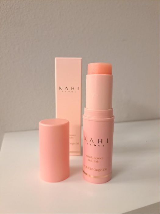 Kahi Wrinkle Bounce Multi Balm stick with the cap removed, placed next to its box.