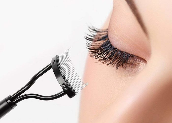 A model using a fine-toothed comb to separate their lashes
