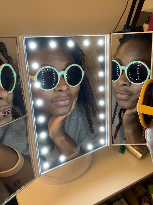 A reviewer illuminated while gazing into the mirror's panels