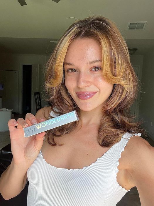 Reviewer wearing the lip gloss and holding the product in hand.