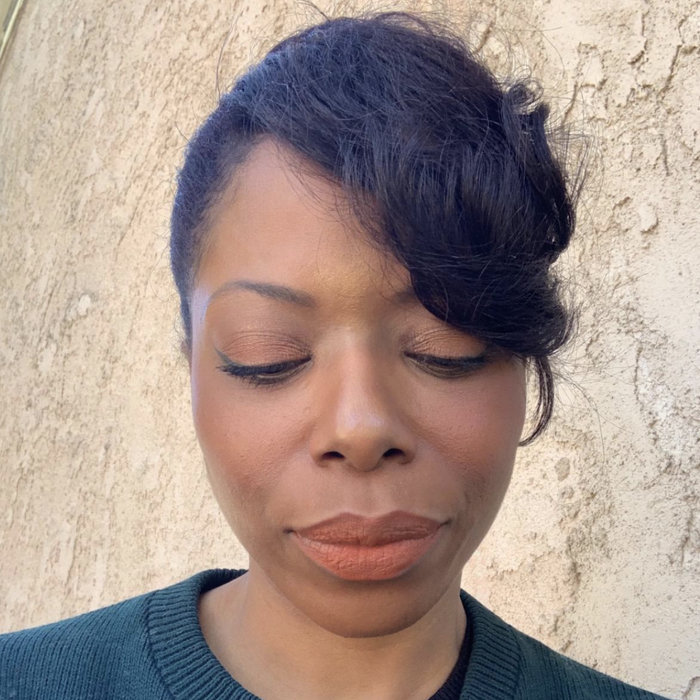 A reviewer applying a nude lipstick.