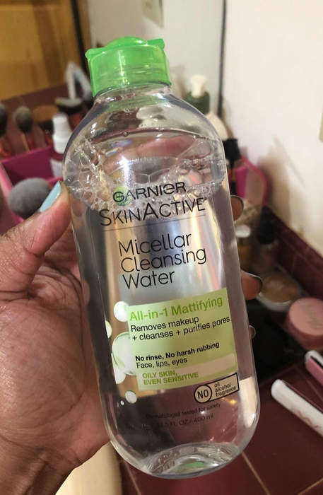 A reviewer holding a bottle of Garnier SkinActive Micellar Cleansing Water