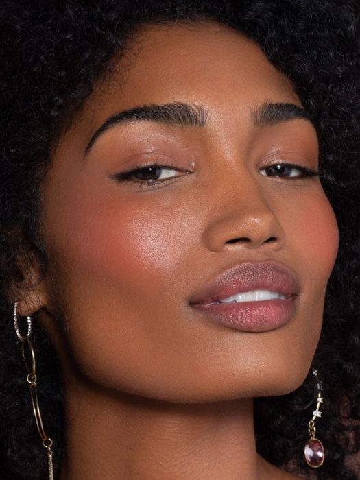 A model wearing the product on their cheeks and lips.