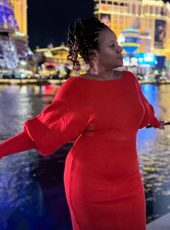 A reviewer showing off the red version of the sweater dress.