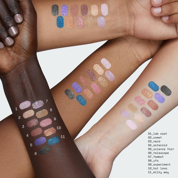 Three arms with swatches of shimmering eyeshadows, numbered 1 to 11. Shades include lab coat, comet, nerd, asteroid, science fair, telescope, and more.