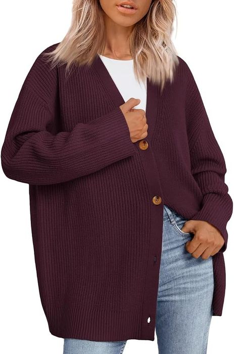 Person wearing an oversized, cozy cardigan with wooden buttons and blue jeans, perfect for casual, chic looks
