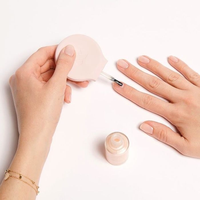 A model using the poppy tool to paint nails.