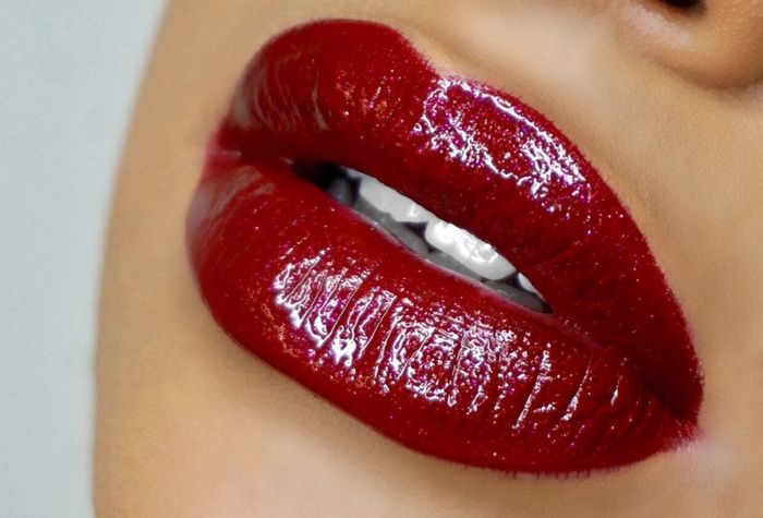 A model sporting a glamorous red, sparkly lip.