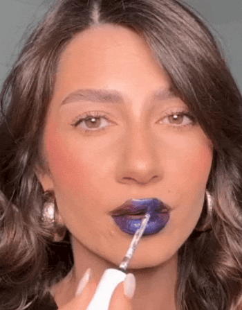 A model applying the blue lip mask, then peeling it off to reveal a stunning maroon lip stain.