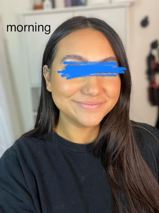 A reviewer smiling while showcasing their makeup.