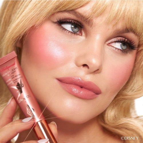 A model showcasing the Disney100 version of the Charlotte Tilbury Beauty Light Wand