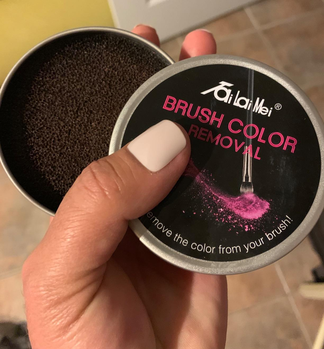 a reviewer holding a tin containing the sponge inside