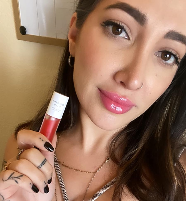 A reviewer showing the Appleberry Lip Oil with it applied to their lips.