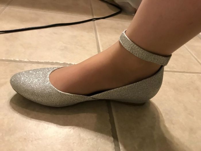 A reviewer wearing sparkling glitter shoes