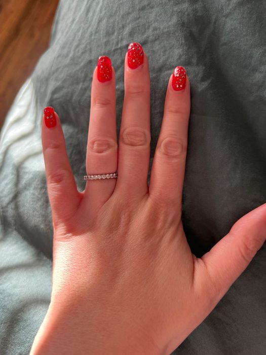 Mytour editor's hand with red nails and silver glitter polish on top