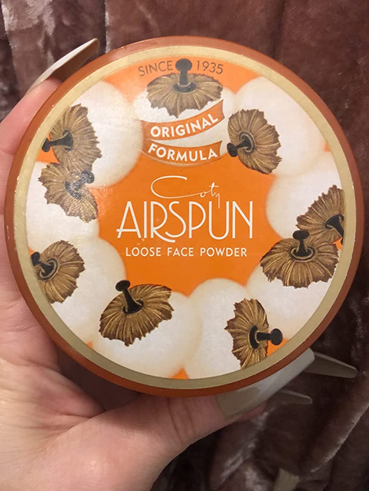 A reviewer holding a container of the setting powder.